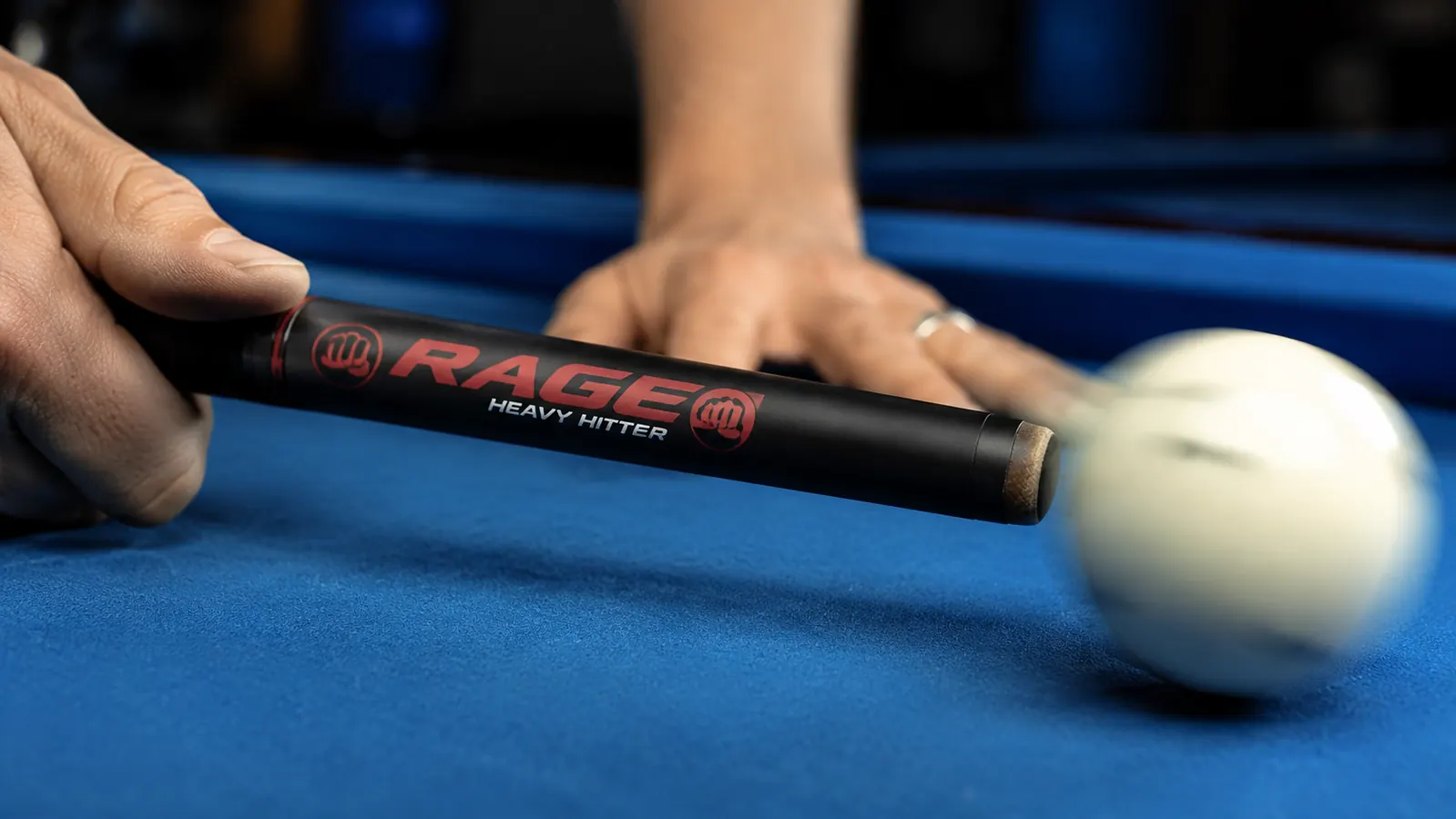 Close-up of a phenolic tip on a break cue pressing against the cue ball at the moment of impact
