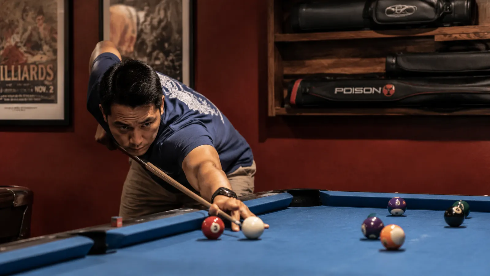 Pool player lining up a shot at an APA league night with cue bag on the rail