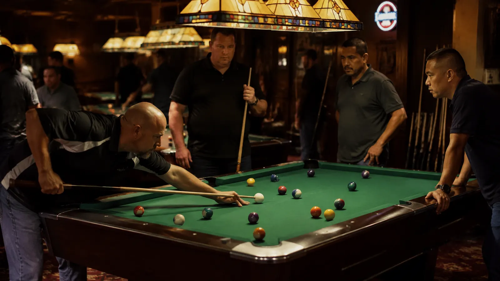 A pool table under warm hall lighting with a cue laid across the felt
