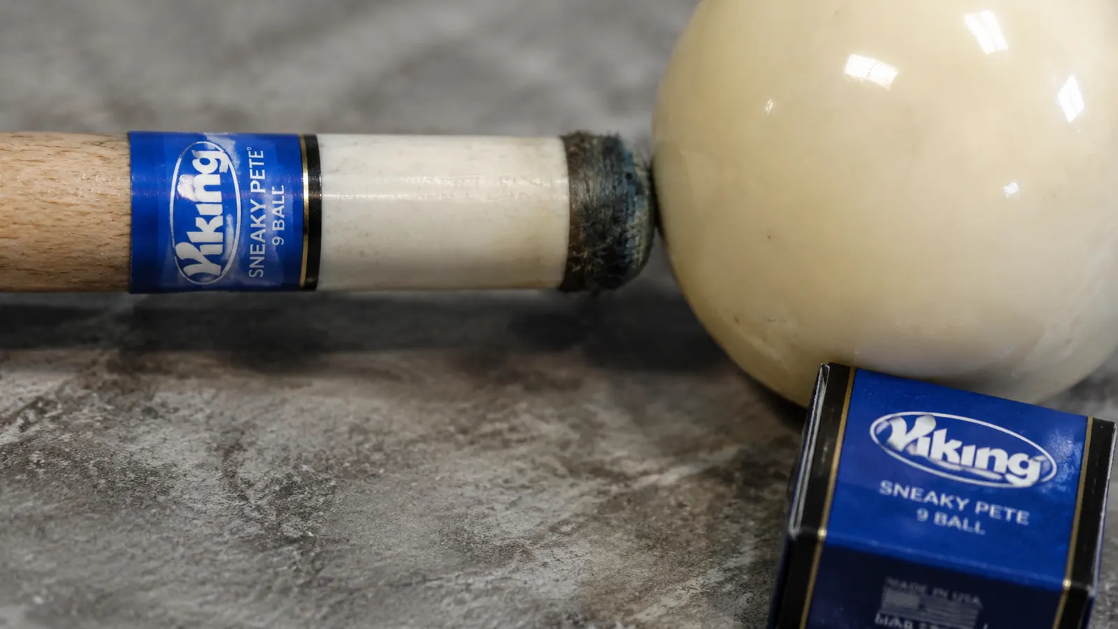 Close-up of a worn pool cue tip showing mushrooming and chalk buildup