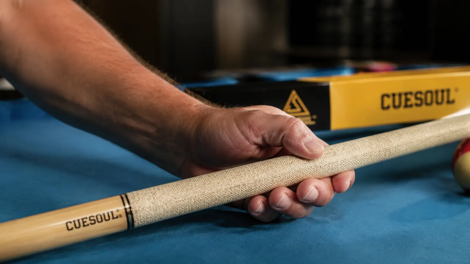 Hand holding a pool cue showing the Irish linen wrap grip area close up