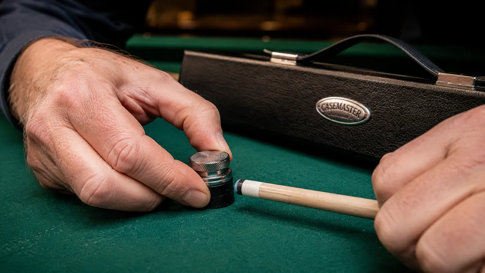 Close-up of a cue tip being shaped with a tip tool on a pool cue ferrule