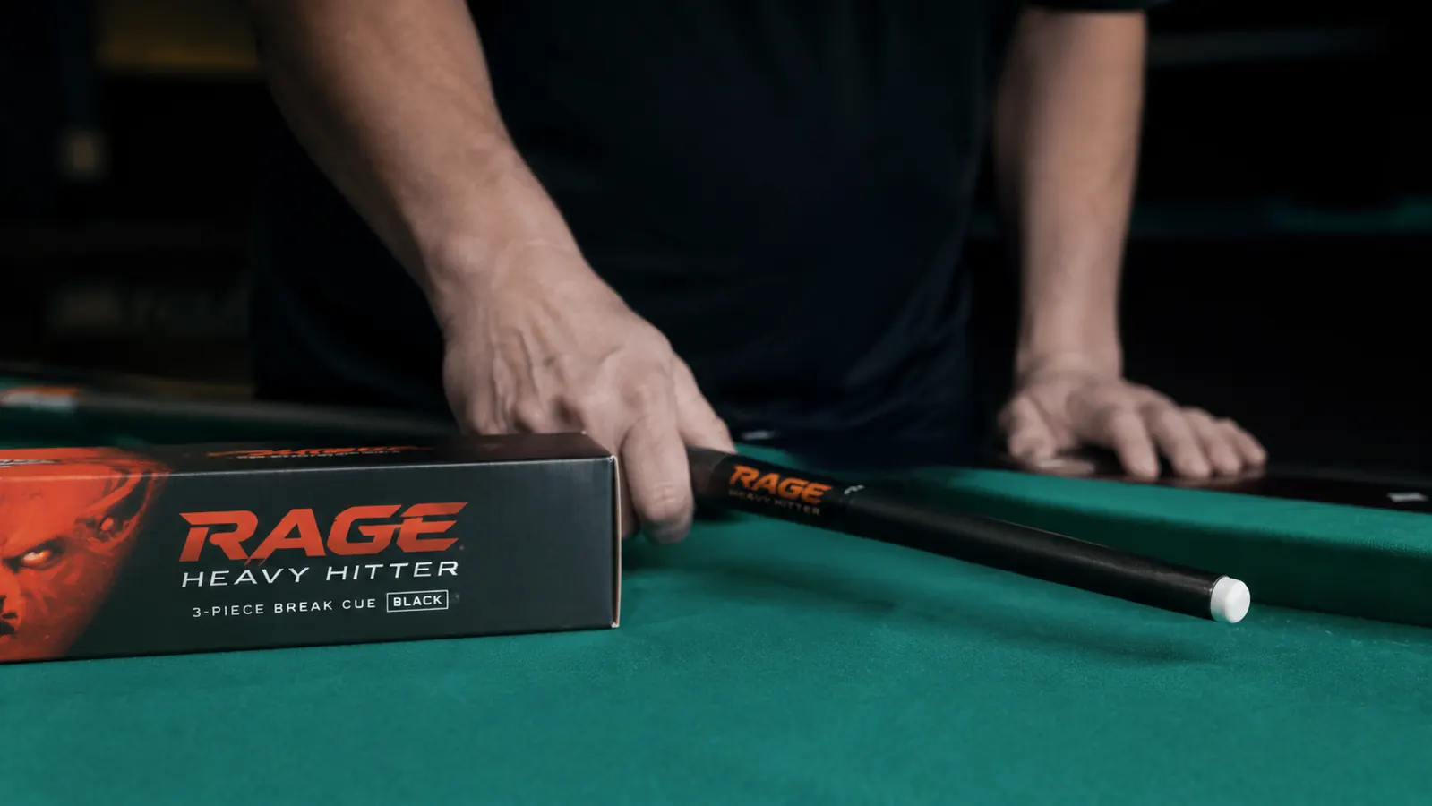 RAGE Heavy Hitter 3-piece jump break cue laid on a pool table rail, phenolic tip visible