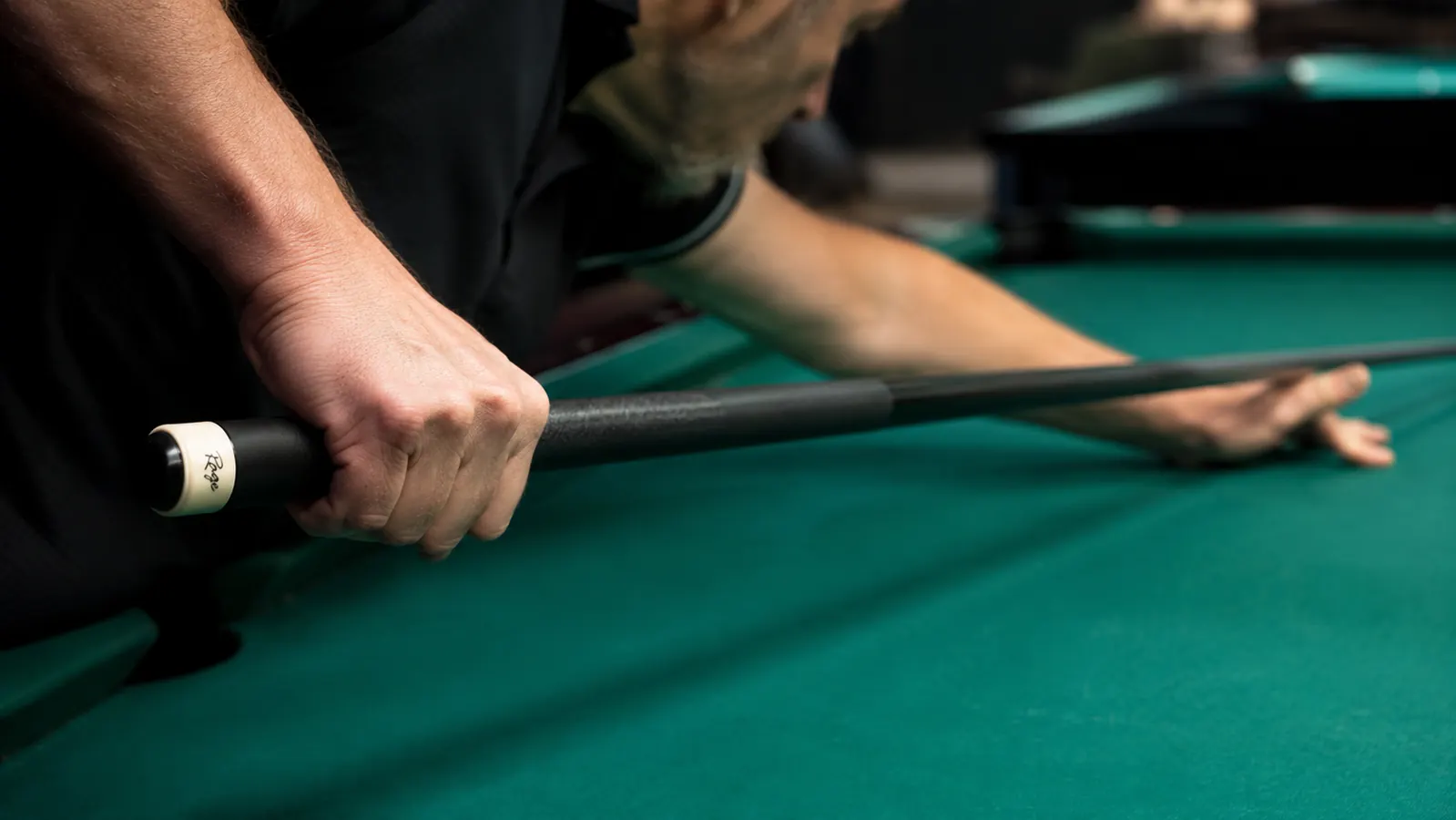Hand gripping the RAGE Heavy Hitter break cue at the joint while preparing a hard break shot